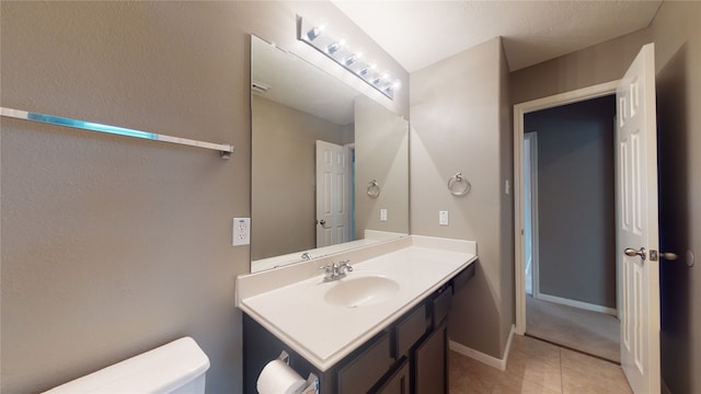 bathroom featuring tile patterned floors, vanity, and toilet