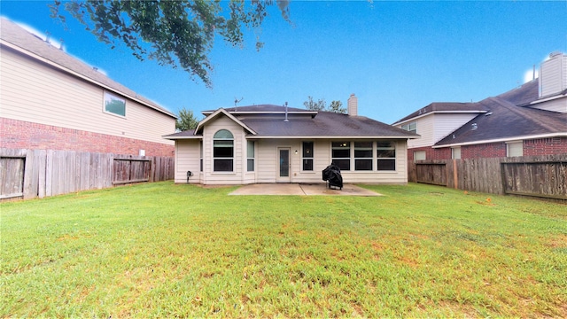 rear view of property featuring a patio area and a yard