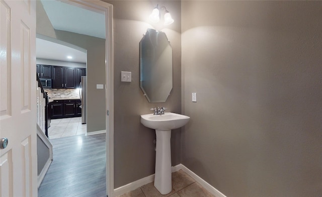 bathroom featuring backsplash, tile patterned floors, and sink