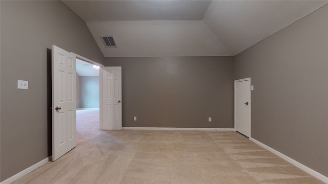 additional living space featuring lofted ceiling and light carpet