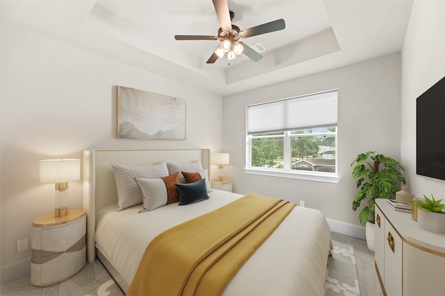 bedroom with ceiling fan, a raised ceiling, and light colored carpet