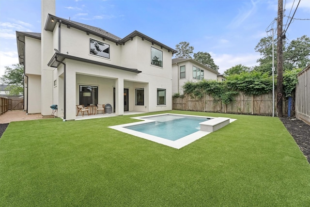 rear view of property featuring a patio, a fenced in pool, and a lawn