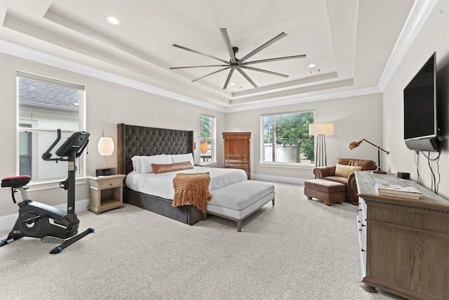 carpeted bedroom with a tray ceiling, ceiling fan, and crown molding