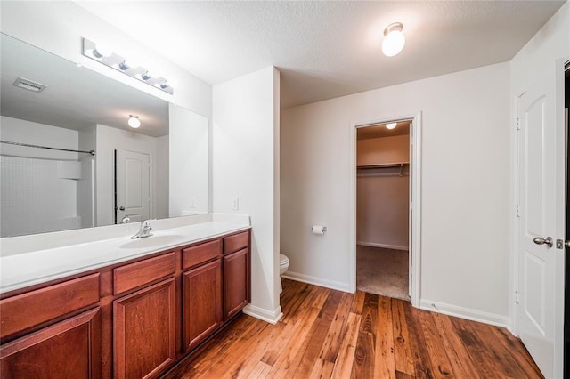 bathroom with wood-type flooring, vanity, and toilet