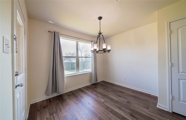 unfurnished dining area with dark hardwood / wood-style flooring and a chandelier