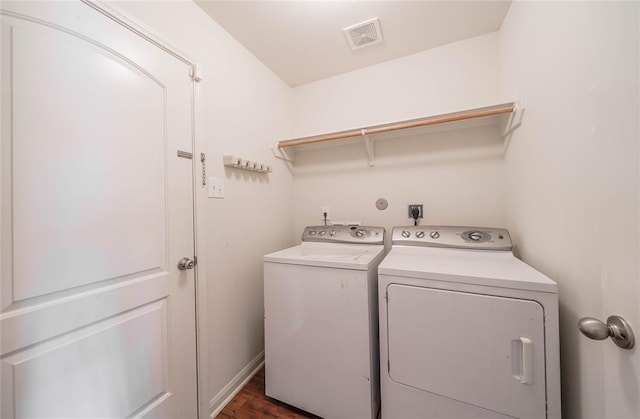 laundry area with dark hardwood / wood-style floors and washing machine and clothes dryer