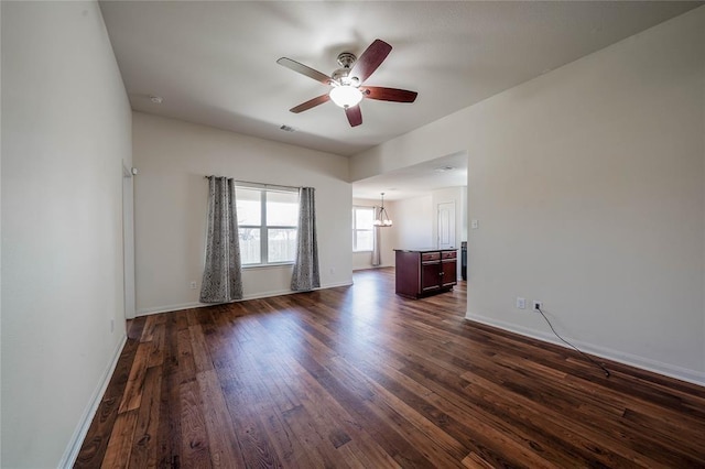 interior space with dark hardwood / wood-style floors and ceiling fan with notable chandelier