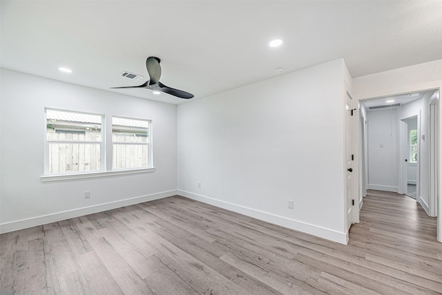 empty room with ceiling fan and light hardwood / wood-style floors