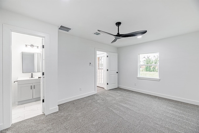 unfurnished bedroom with ensuite bathroom, ceiling fan, and light carpet