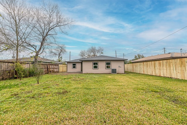 rear view of house featuring a lawn and central air condition unit