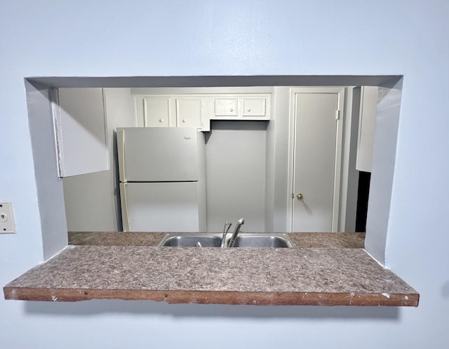 kitchen featuring white cabinets, white refrigerator, kitchen peninsula, and sink