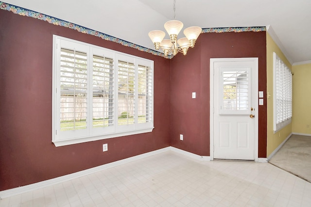 foyer entrance with a wealth of natural light, ornamental molding, and a notable chandelier