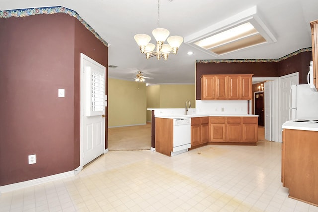 kitchen featuring kitchen peninsula, ceiling fan with notable chandelier, white appliances, sink, and decorative light fixtures