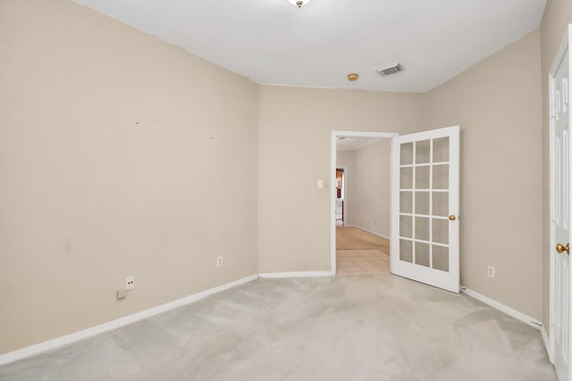 unfurnished room with french doors and light colored carpet