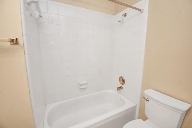 bathroom featuring tiled shower / bath combo and toilet