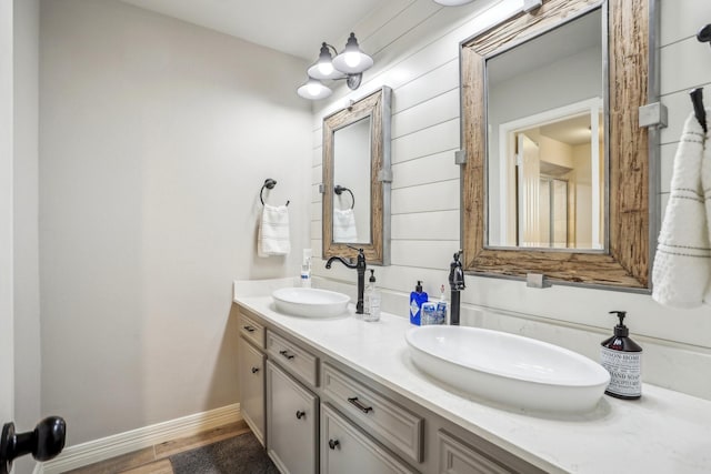 bathroom with wood-type flooring, vanity, and wood walls