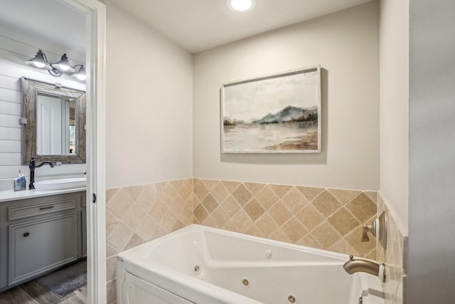 bathroom featuring tile walls, a bathtub, hardwood / wood-style flooring, and vanity