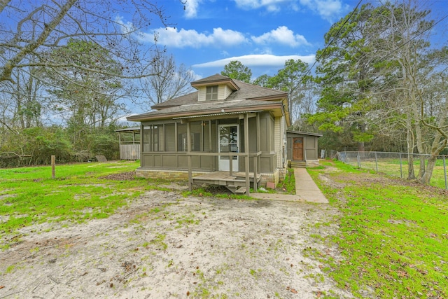 view of front of house with a front lawn and a sunroom