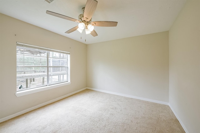 carpeted spare room featuring ceiling fan