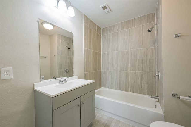 full bathroom featuring vanity, toilet, and tiled shower / bath