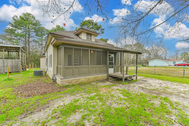 view of front of home featuring a sunroom and cooling unit