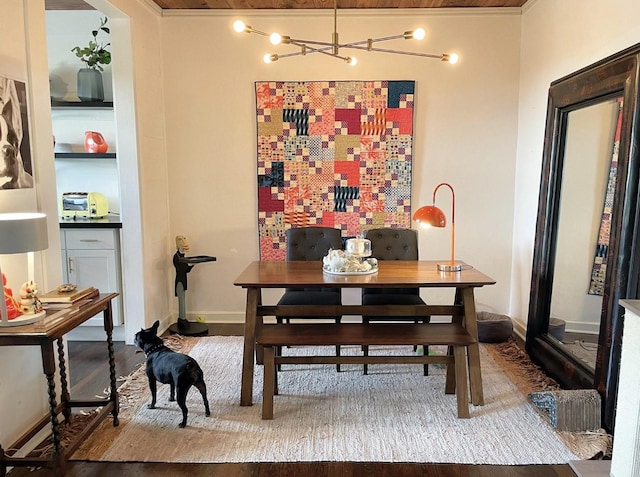 dining room with hardwood / wood-style flooring, built in features, and a notable chandelier