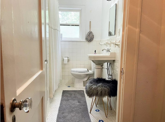 bathroom featuring a shower with shower curtain, sink, tile walls, tile patterned flooring, and toilet