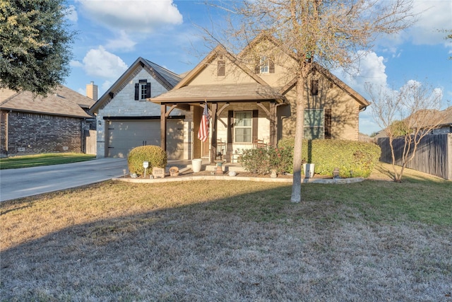 view of front of home with covered porch, a front yard, and a garage