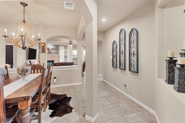 dining space featuring ceiling fan with notable chandelier and light tile patterned floors