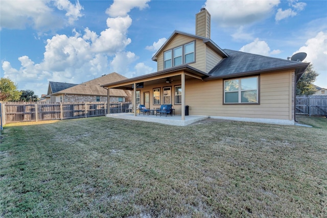 back of property with a lawn, ceiling fan, and a patio area