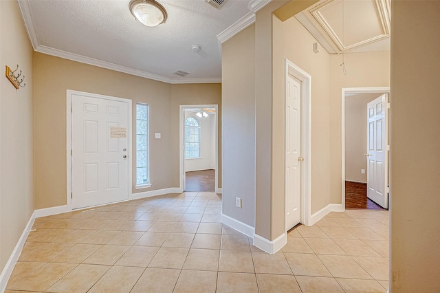 entryway with crown molding, light tile patterned floors, a textured ceiling, and ceiling fan