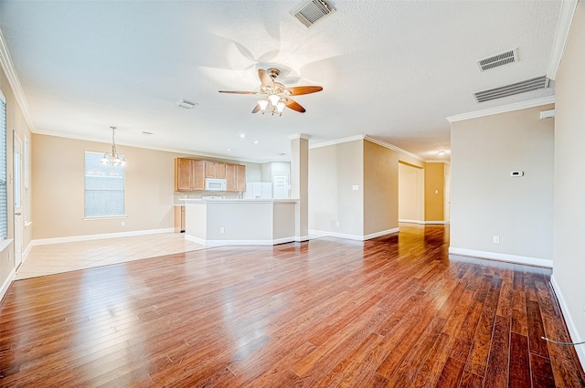 unfurnished living room featuring a textured ceiling, light hardwood / wood-style floors, ceiling fan with notable chandelier, and ornamental molding