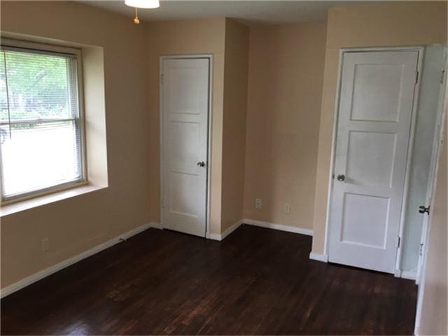 unfurnished bedroom featuring dark wood-type flooring