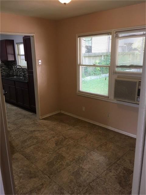 unfurnished room featuring cooling unit and sink