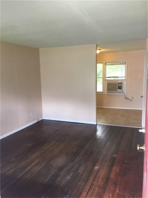 spare room featuring cooling unit and dark hardwood / wood-style floors