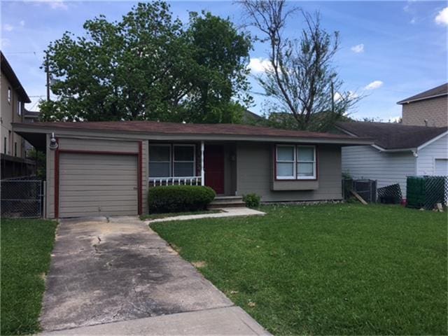 ranch-style home with a garage, covered porch, and a front lawn