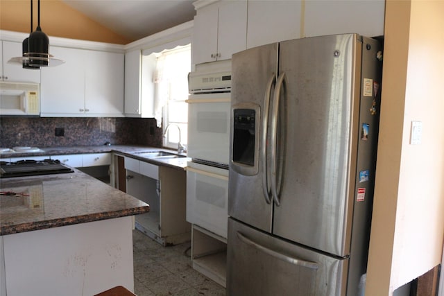 kitchen featuring sink, white cabinets, dark stone counters, and white appliances