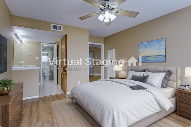 bedroom featuring ensuite bath, light hardwood / wood-style flooring, and ceiling fan