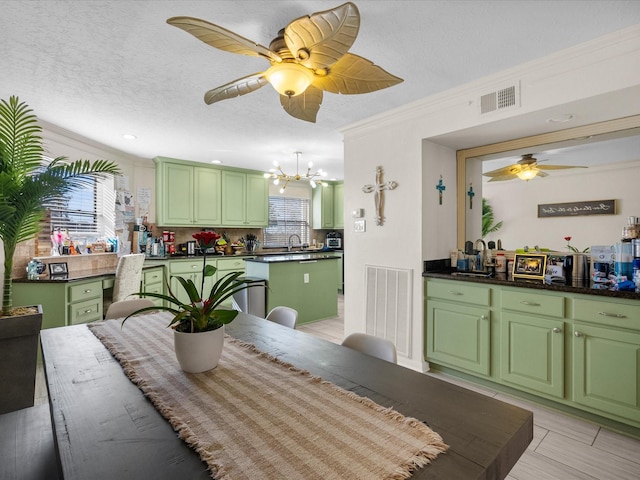 dining area featuring crown molding, sink, an inviting chandelier, and a textured ceiling