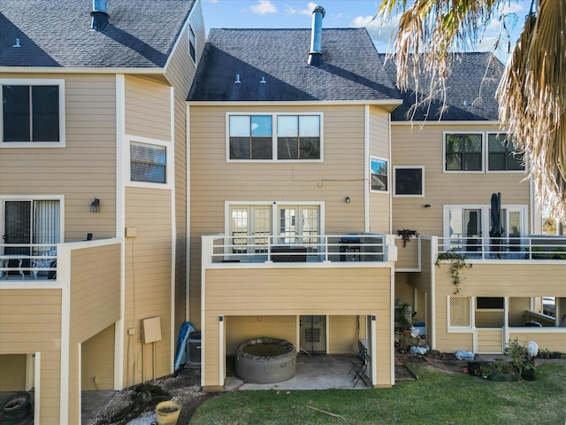 back of property with a balcony and a patio