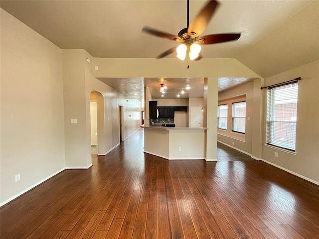 unfurnished living room with ceiling fan, dark hardwood / wood-style flooring, and lofted ceiling