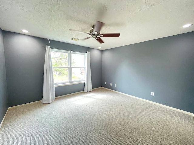 carpeted empty room with a textured ceiling and ceiling fan