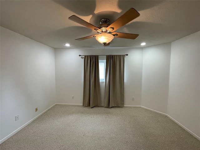 carpeted spare room featuring ceiling fan