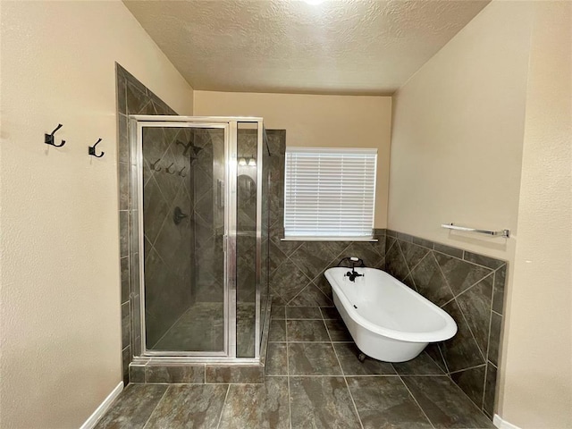 bathroom with tile patterned floors, plus walk in shower, and a textured ceiling