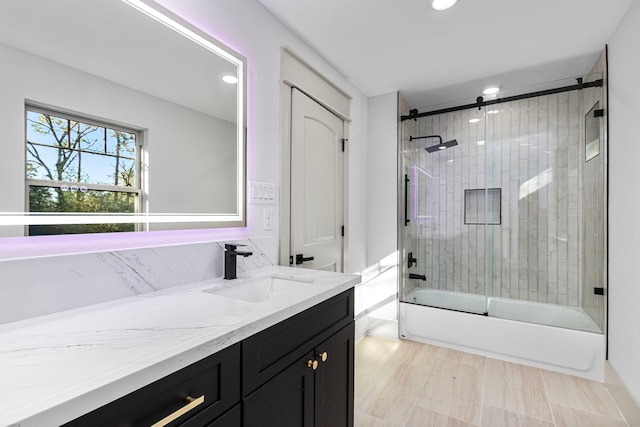 bathroom with vanity and bath / shower combo with glass door