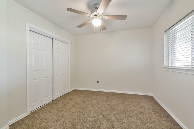 unfurnished bedroom featuring ceiling fan, carpet flooring, and a closet