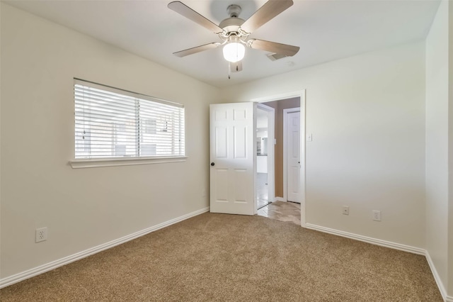 spare room featuring ceiling fan and light colored carpet