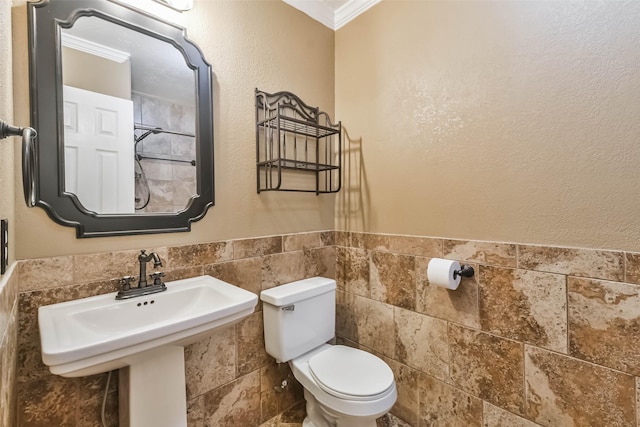 bathroom featuring crown molding, sink, tile walls, and toilet