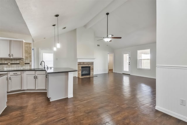 kitchen with sink, beamed ceiling, dark hardwood / wood-style flooring, pendant lighting, and ceiling fan