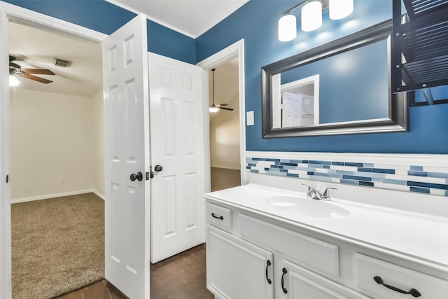 bathroom with ceiling fan, vanity, and decorative backsplash